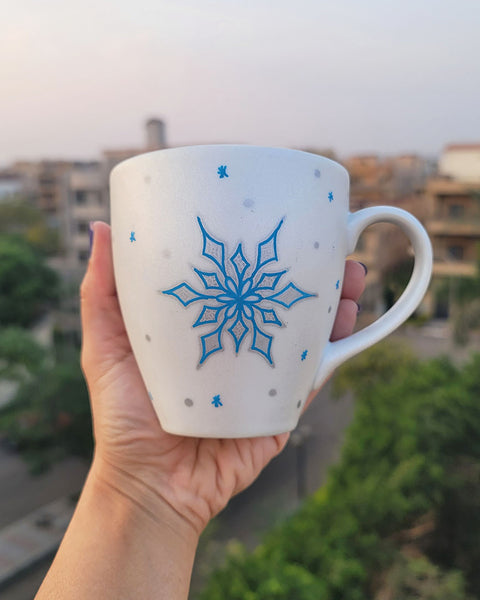 A Pearl White Hand painted mug with a snowflake inurquoise