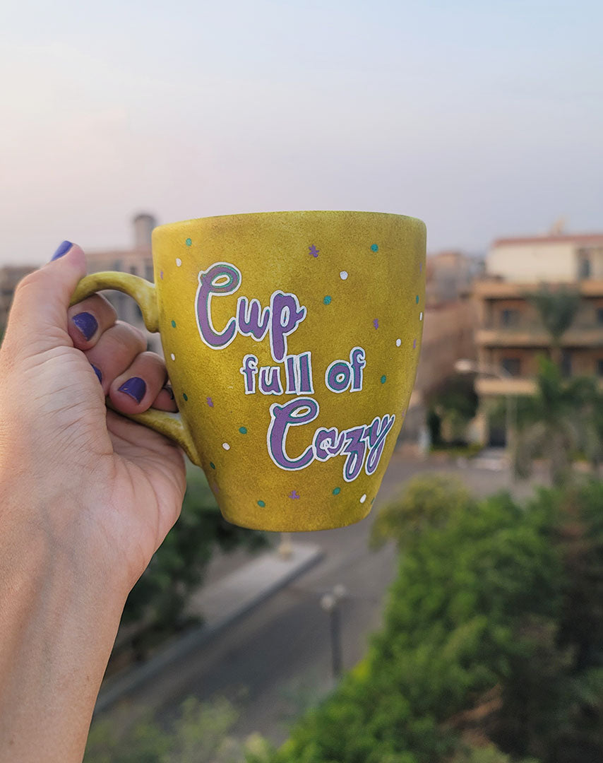 A Handpainted Greenish Bronze Mug with the sentence "Cup full of Cozy" in purple