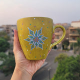 A Handpainted Greenish Bronze Mug with A Snowflake Painted in purple