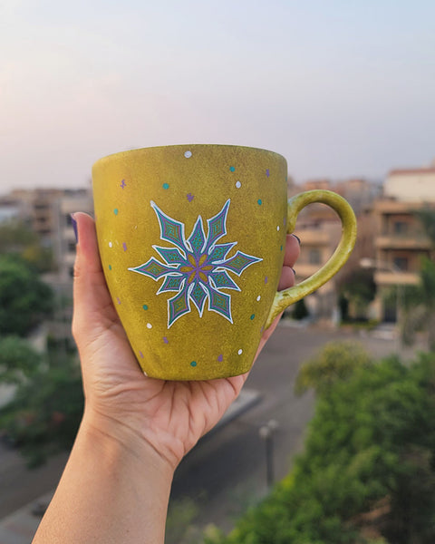 A Handpainted Greenish Bronze Mug with A Snowflake Painted in purple