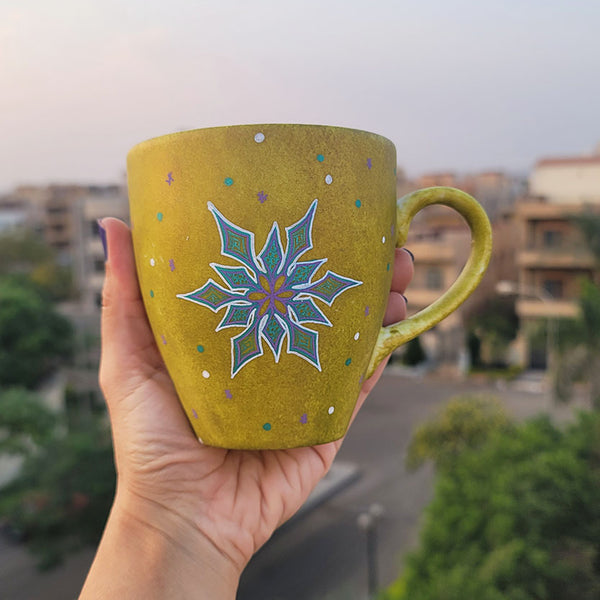 A Handpainted Greenish Bronze Mug with A Snowflake Painted in purple