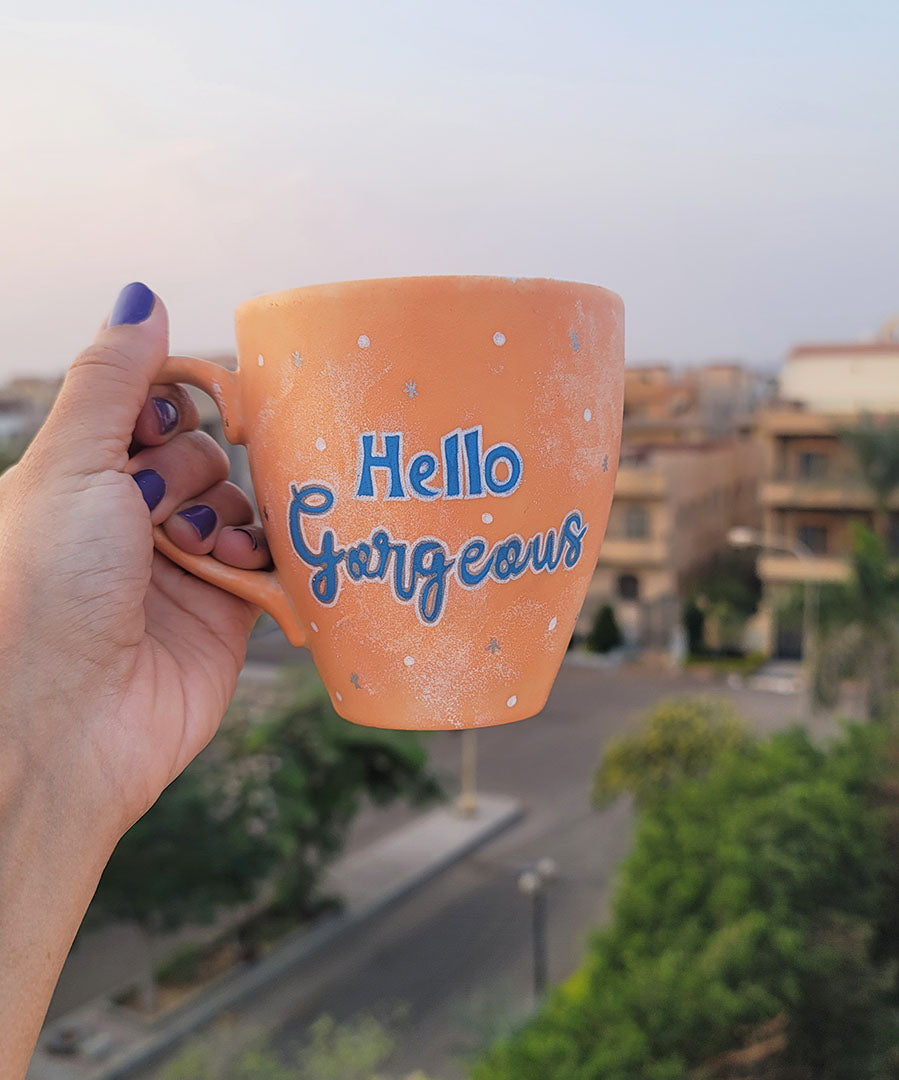 A Baby Orange Hand-painted mug with the words "hello gorgeous"