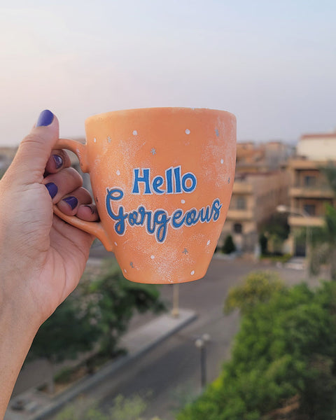 A Baby Orange Hand-painted mug with the words "hello gorgeous"