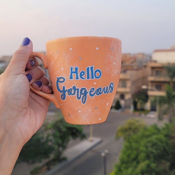 A Baby Orange Hand-painted mug with the words "hello gorgeous"