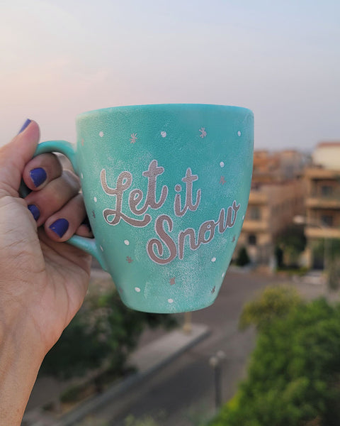 A Mint hand painted mug with the words "let it snow" in silver