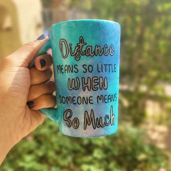 A Blue Galaxy hand painted mug with the words "Distance means so little "