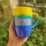 A Gradient colored hand painted mug with gradient colors of yellow turquoise and blue, with the name 