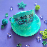 A Green Galaxy Hand painted cup and saucer with the sentence 