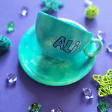 A green galaxy hand painted cup and saucer with the name 