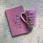 A Pastel Pink Hand painted gift set of mug and notebook with the name Dina wirtten on top and under it the sentence "the bravest heart and kindest Soul" all wirtten in black and colored in purple, pink, green and blue.