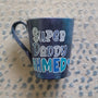 A dark Sky Hand painted mug with the words "Super Daddy Ahmed " and a heart