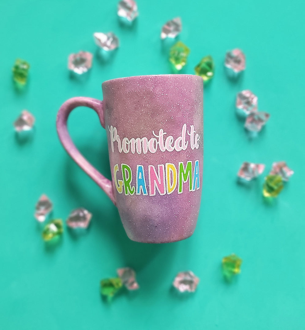 A Pink Pastel Galaxy hand painted mug with the words "Promoted to Grandma"