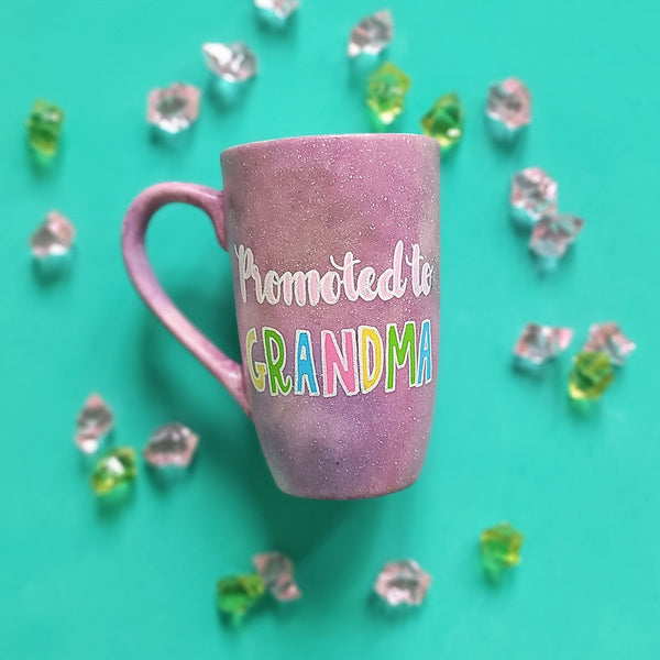 A Pink Pastel Galaxy hand painted mug with the words "Promoted to Grandma"