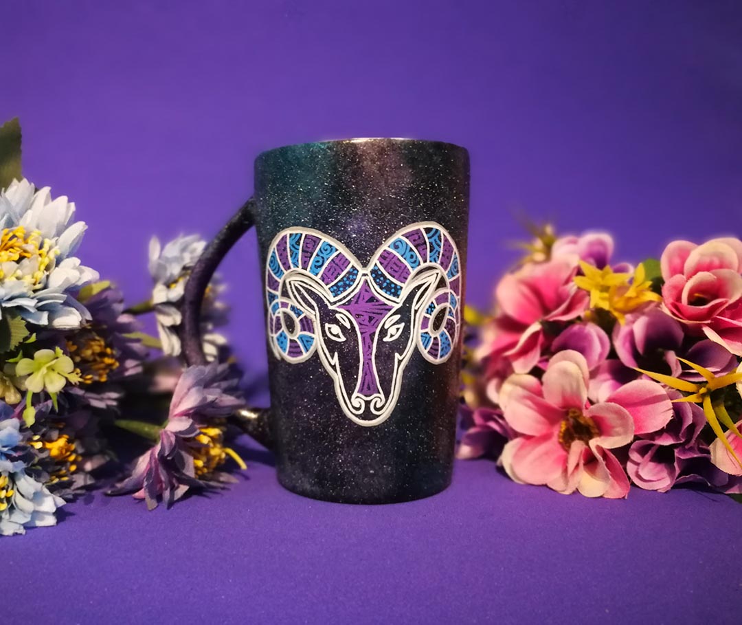 A Hand-painted black galaxy mug with the Aries sign