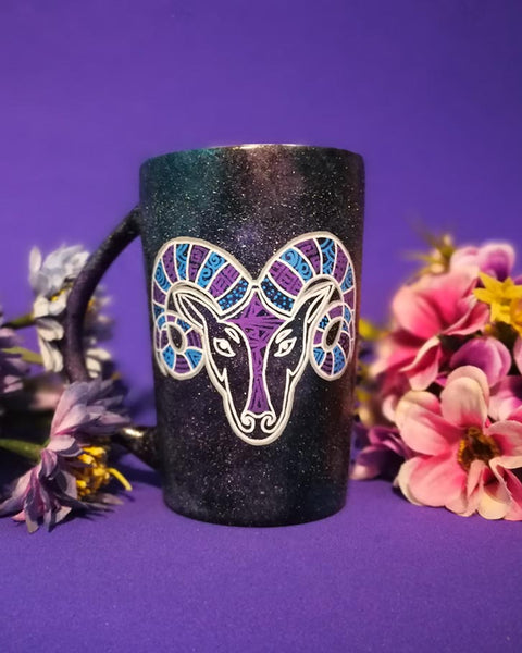 A Hand-painted black galaxy mug with the Aries sign