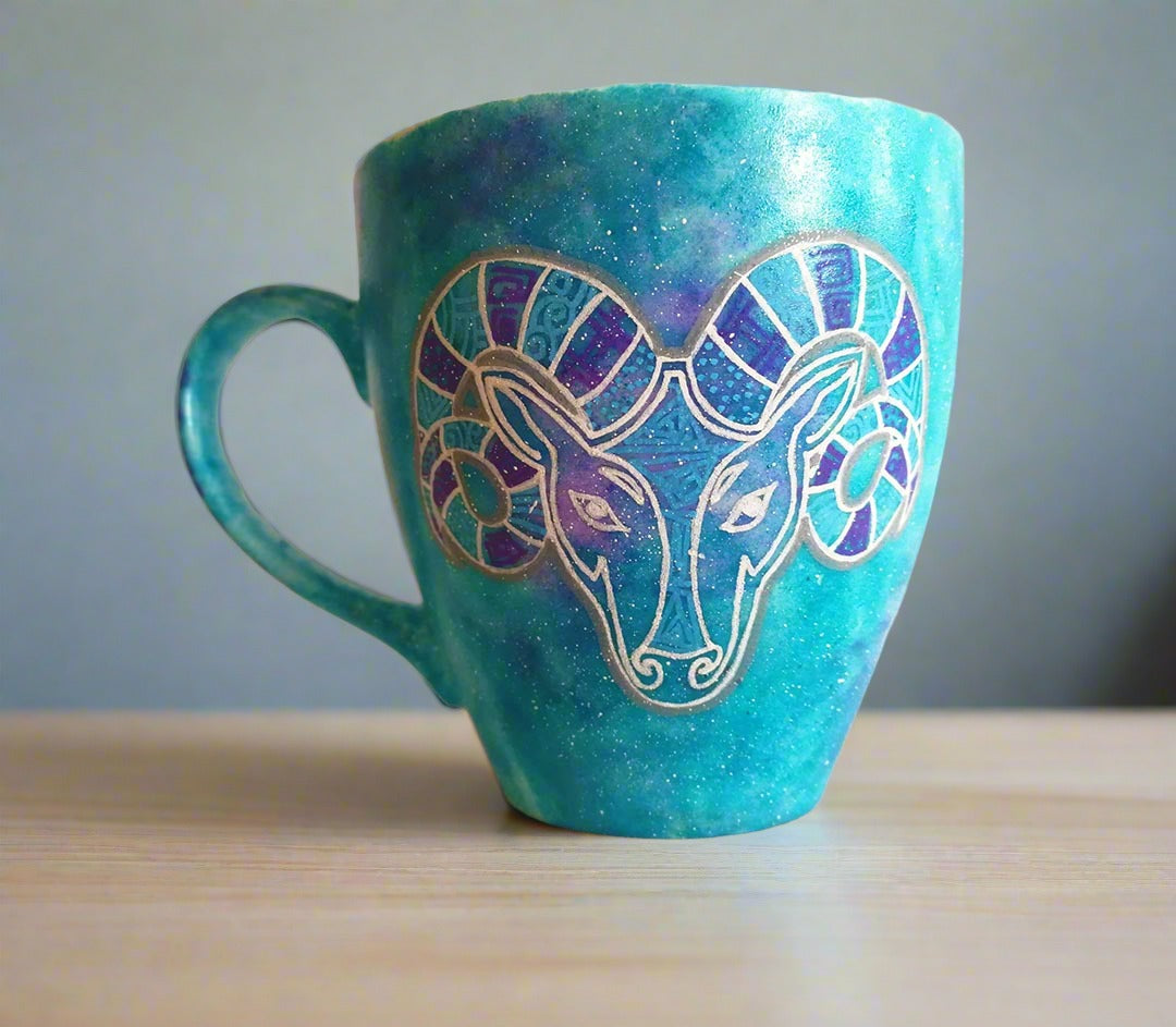 A Hand-painted blue galaxy mug with the Aries sign