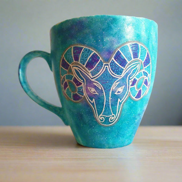 A Hand-painted blue galaxy mug with the Aries sign