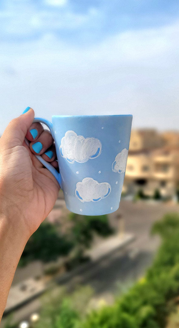 A Baby Blue Hand painted mug with white clouds drawn on it