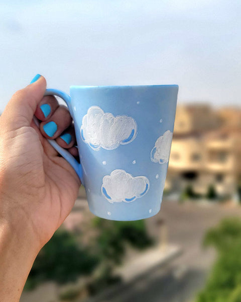 A Baby Blue Hand painted mug with white clouds drawn on it