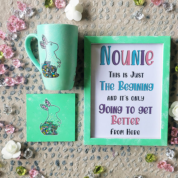 A Mint Green Hand painted gift set containing a mug with a a bunny design a matching coaster and a frame with the name "Nounie" and a quote.