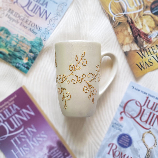 A Pearl white hand painted mug with classical curves and leaves painted by gold relief