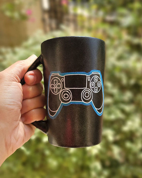 A Black sky mug with a joystick drawn on it