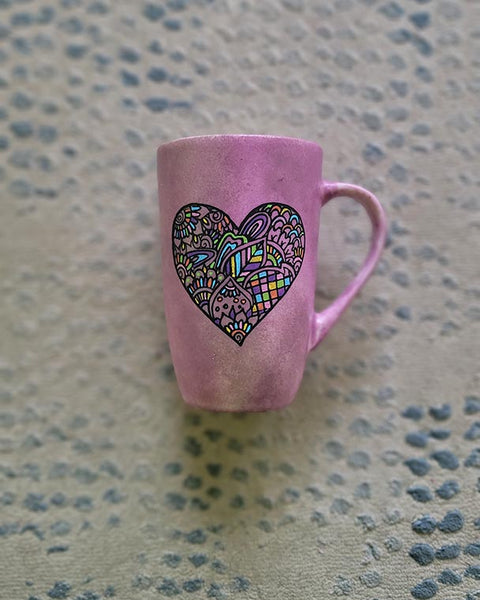 a Pastel Pink hand painted mug with a heart drawn in black filled with colorful patterns