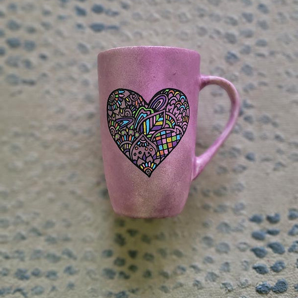 a Pastel Pink hand painted mug with a heart drawn in black filled with colorful patterns