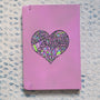 a Pastel Pink hand painted Notebook with a heart drawn in black filled with colorful patterns