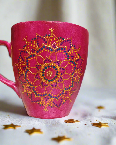 A hand painted pink Indian color mug with a mandala painted in gold