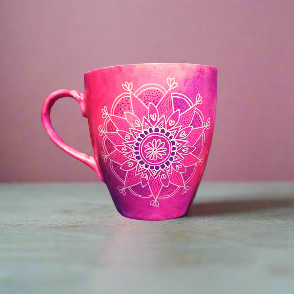 A Pink hand painted mug with a mandala drawn in white and colored in purple and pink