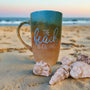 A gradient colored hand painted mug (from sand color at the botom to the sea color on top) with the words "the beach is calling"