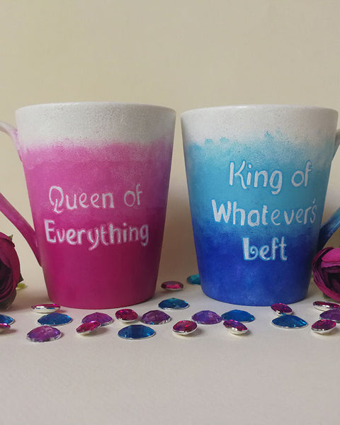 2 hand-painted mugs. One with gradients of pink and has the words "queen of everything" and the other is colored in gradients of blue and has the words "King of whatever's left"