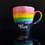 A Mug with the top half painted in rainbow and the bottom in dark galaxy, with the name on the dark galaxy 