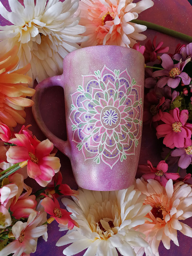 A Pastel Pink Hand Painted mug with a mandala painted in the center with white