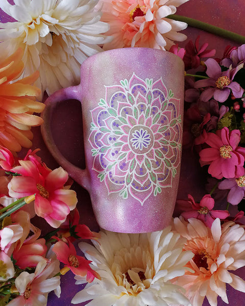 A Pastel Pink Hand Painted mug with a mandala painted in the center with white