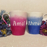 2 hand-painted mugs. one colored in gradient blues to white and has the name 