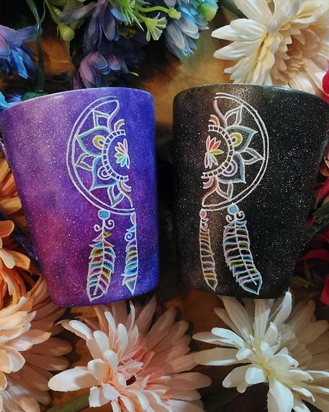 Two Hand-painted mugs one in purple galaxy color and the other black galaxy color  with a dreamcatcher divided in two , one on each mug