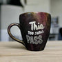 A Black galaxy mug with the words "this too shall pass"