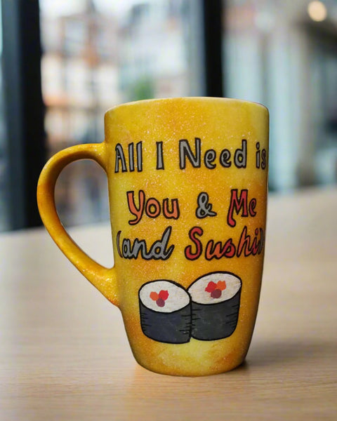 A Hand Painted Yellow Orange Galaxy Mug with the sentence "All I need is You and ME and Sushi" and 2 sushi rolls drawn below it