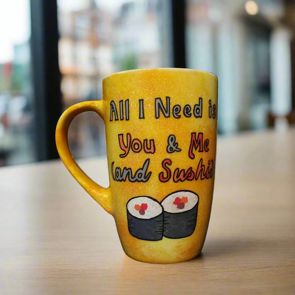 A Hand Painted Yellow Orange Galaxy Mug with the sentence "All I need is You and ME and Sushi" and 2 sushi rolls drawn below it