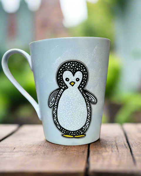 A baby blue hand painted mug with a zentangle baby penguin painted