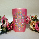 A Shimmery pink hand painted mug with a mandala split into 2 with a space in between that has the name 