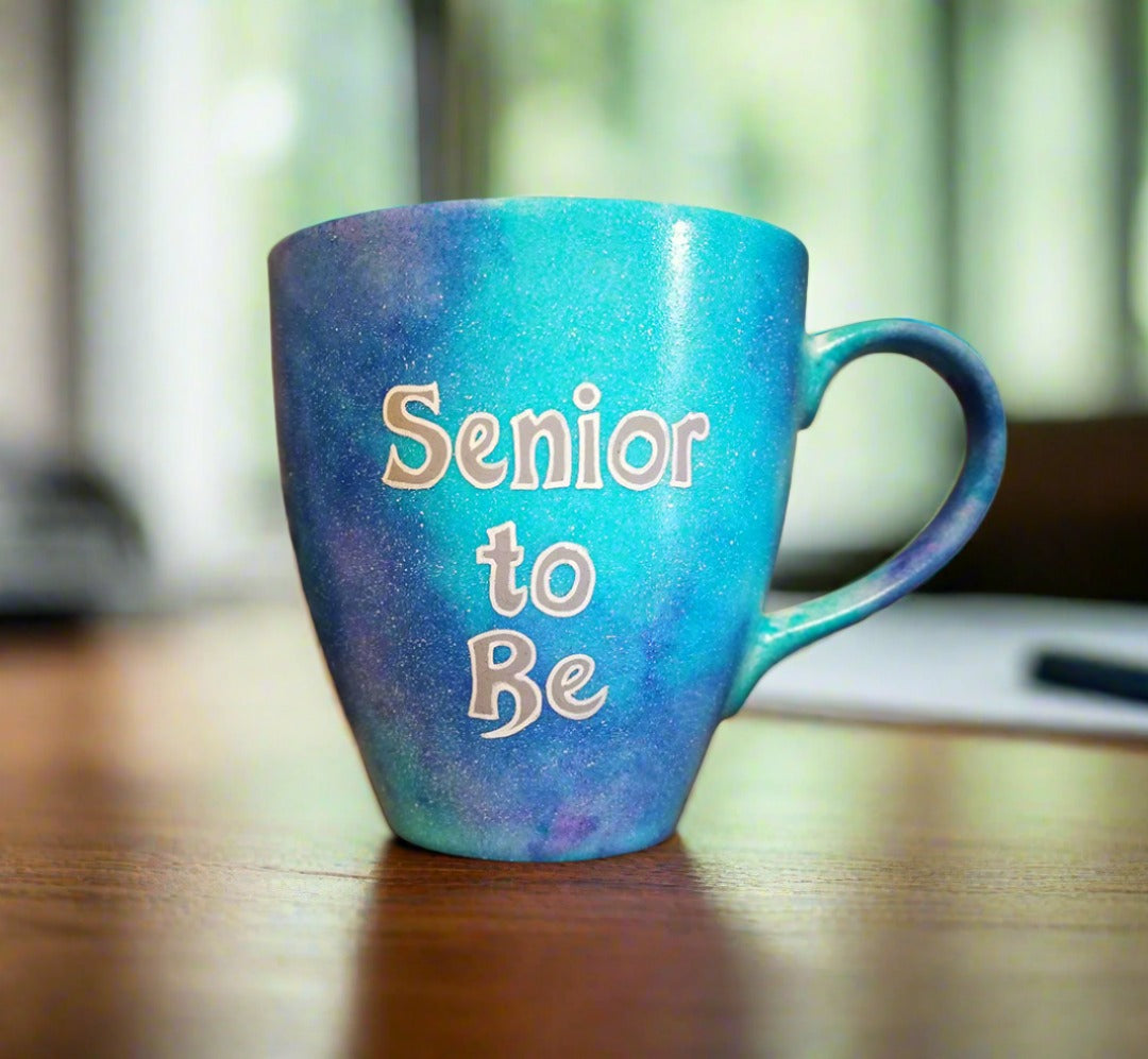 A Blue galaxy hand painted mug with the words "Senior to be"