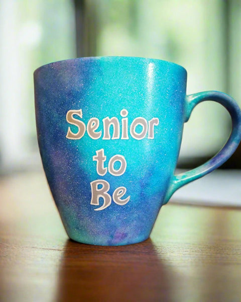 A Blue galaxy hand painted mug with the words "Senior to be"