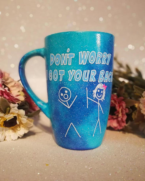 A hand painted blue galaxy mug with the words "don't worry, I got your back " and a drawing of 2 stick figures with the girl holding the back of the boy