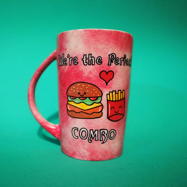 A hand-painted red galaxy mug with the words "we're the perfect combo"