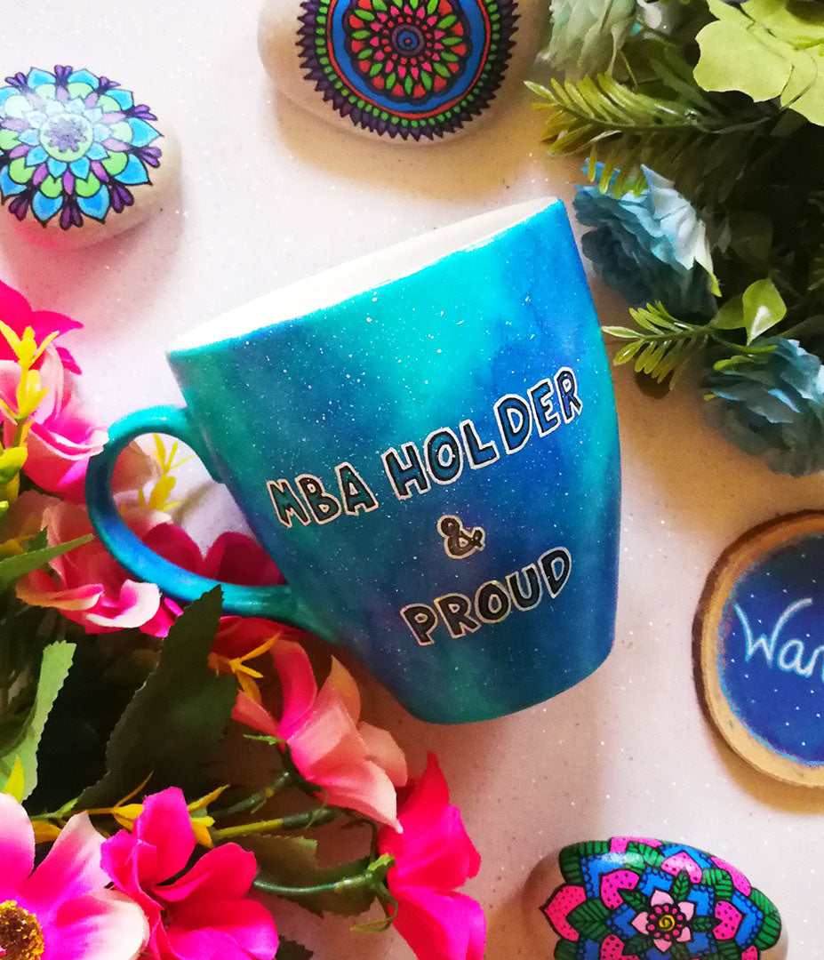 A Blue Galaxy hand painted mug with the words "MBA holder and proud"