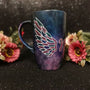 A Dark Sky hand painted mug with a wing drawn on one side 