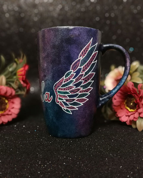 A Dark Sky hand painted mug with a wing drawn on one side 